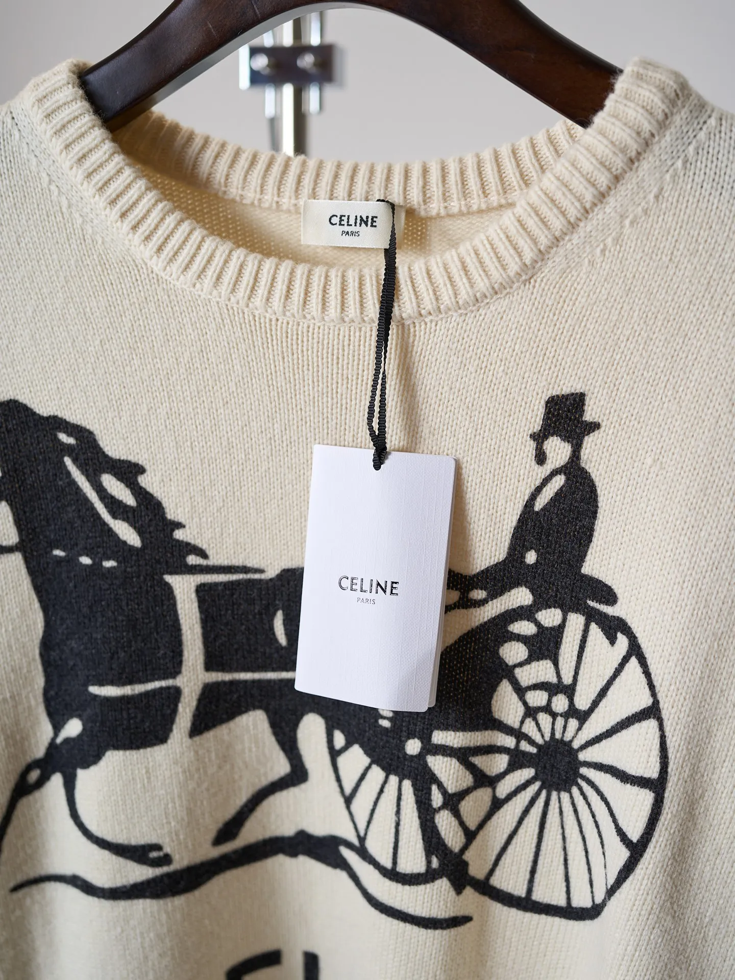 [Real object hanging] CELINE/Celine carriage print round neck knitted sweater [In Stock] S M L XL Fabric selection: Made of 62% wool + 23% nylon + 15% anti-pilling acrylic blended yarn, precision woven on an imported 7-needle knitting machine. The 7-needle medium-thick knitted structure makes the fabric fluffy and thick, with excellent temperature-locking ability; wool gives the fabric a soft, waxy and skin-friendly texture, while nylon strengthens the toughness and prevents it from loosening and deforming. It is paired with anti-pilling acrylic to give it both comfort and durability, and a solid texture. Printing process: The Classic carriage pattern and letters on the chest adopt a reactive printing process. The dye penetrates into the knitted fiber and is not offset printed on the surface. The pattern lines are clear and neat, and the touch is natural without a hard glue layer. It is not easy to crack or peel after repeated wear and washing, and the original soft texture of the knitted fabric is completely retained. Details: The round neck, cuffs and hem are made of high-density wide rib weaving, which has long-lasting elasticity and will not loosen easily after long-term wear; the back shoulders are made of hollow keyhole technology, and the entire line is evenly routed.
